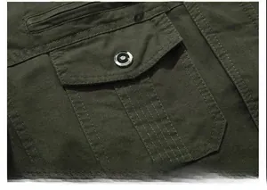 Detail of army green cotton jacket sleeve featuring metal zipper pocket and canvas texture