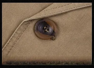 Dettaglio macro del bottone tartarugato e tessuto twill di un blazer casual marrone