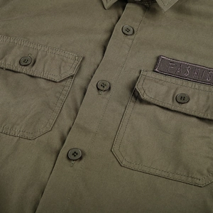 Detail of army green twill cotton shirt featuring chest pockets and fashion embroidery