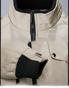 Detail of khaki outdoor jacket showing black ribbed collar and sturdy metal zipper closure