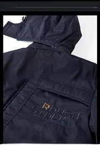 Detailed close-up of navy blue winter jacket featuring high-quality golden letter embroidery