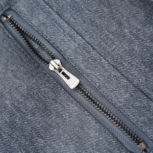 Macro shot of silver metal zipper on vintage charcoal grey faux leather jacket