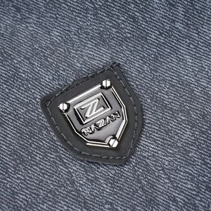 Close-up of a jacket's high-density fabric texture with an embossed silver shield logo
