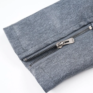 Detailed macro view of vintage metal zipper on grey-blue mottled faux leather jacket cuff