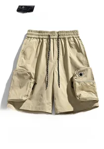 Detail of khaki cargo shorts with 3D pockets, mesh panels, and metal ring accents