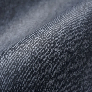 Macro detail of high-quality dark grey twill denim fabric with washed vintage texture