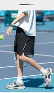 Detailed view of black lightweight athletic shorts with side stripes on a tennis court