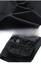 Detail of water-repellent fabric with mesh pockets and metal eyelets on cargo pants
