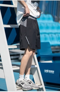 Detail of cargo shorts showing elastic waistband with drawstrings and reflective side stripes
