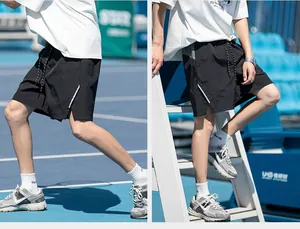 Detail view of men's sports shorts with elastic waistband, drawstrings and side slits