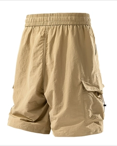 Detail of khaki cargo shorts showing elastic waistband and large side utility pockets