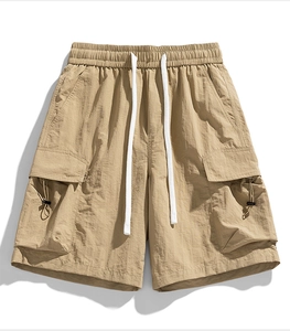 Detailed close-up of khaki cargo shorts showing nylon texture and elastic drawstring waist