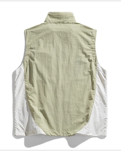Dettaglio del gilet outdoor verde salvia e bianco con colletto dritto e tessuto stropicciato