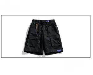 Detail of black utility cargo shorts with adjustable buckle and yellow drawstrings