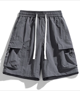 Detail of dark grey utility cargo shorts featuring adjustable drawstring and buckle pockets