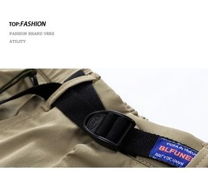 Detailed close-up of khaki cargo shorts with nylon belt buckle and woven brand label
