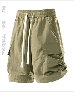 Detail of cargo shorts showing olive green fabric, elastic waistband and functional pocket
