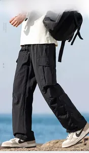 Detail of black lightweight cargo pants featuring large side pockets and drawstring waist