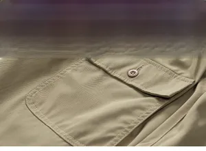 Macro shot of khaki cargo shorts showing high-density twill fabric and button pocket