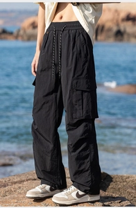 Detail of black lightweight cargo pants showing elastic drawstring waist and side pockets