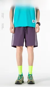 Dettaglio dei pantaloncini sportivi viola con tre strisce laterali bianche e coulisse