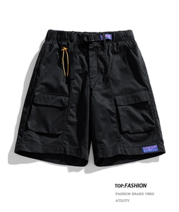 Detailed flat lay of black cargo shorts with elastic drawstring waist and large utility pockets