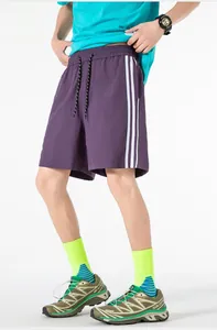 Dettaglio dei pantaloncini sportivi viola con tre strisce laterali e coulisse elastica