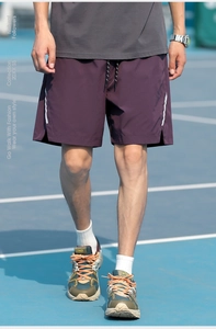 Detail of dark purple sports shorts with drawstring waist and white side stripes