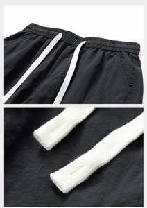 Detail view of water-resistant cargo shorts featuring elastic waist and white drawstring