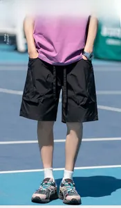 Detail of men's black cargo shorts with utility pockets on a blue tennis court
