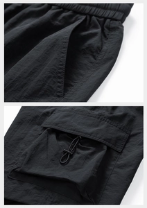 Detail of cargo shorts featuring elastic drawstring waist and large flap utility pockets