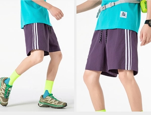 Dettaglio di pantaloncini sportivi viola con vita elastica e strisce laterali bianche