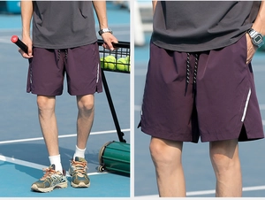 Detail view of plum purple athletic shorts featuring reflective side stripes and drawstring