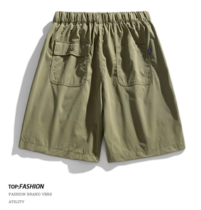 Detail of olive green cargo shorts with elastic drawstring waist and back button pocket