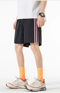 Dettaglio dei pantaloncini sportivi neri con strisce rosa laterali e coulisse regolabile