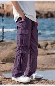 Detail of purple Gorpcore cargo pants with large flap pockets and adjustable drawstring