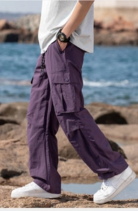 Detail of purple cargo pants showing large utility side pockets and drawstring waist
