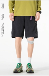 Detail of black cargo shorts with large flap pockets and a purple webbing accent belt