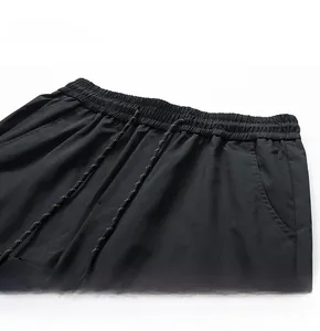 Detail of high-elastic waist with white drawstring on water-resistant black cargo shorts