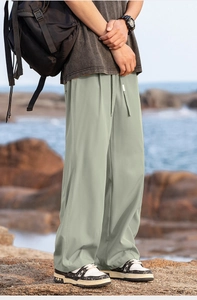 Close-up of sage green quick-dry hiking pants with adjustable drawstring waist for camping