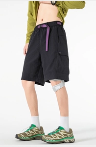 Detail of black utility shorts featuring a purple woven belt and cargo side pockets