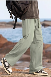 Detail of light green wide-leg trousers featuring elastic drawstring waist and side pockets