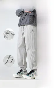 Detailed view of elastic waist with drawstring and zipper pocket on grey hiking pants