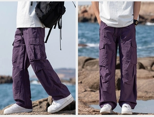 Detail view of purple multi-pocket cargo pants with drawstring waist and straight leg cut