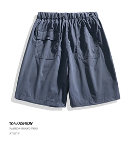 Macro detail of elastic waistband and large functional cargo pockets on grey shorts
