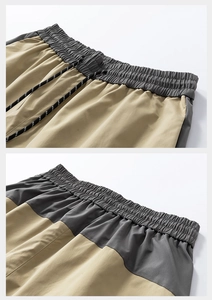 Detail of cargo shorts waist featuring khaki and grey patchwork with adjustable drawstrings