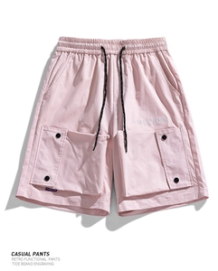 Detail view of light pink cargo shorts featuring waterproof fabric and side utility pockets