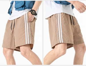 Vista dettagliata dei pantaloncini sportivi marroni con strisce laterali ed elastico