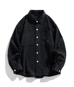Detailed macro shot of black corduroy fabric texture and white button on chest pocket