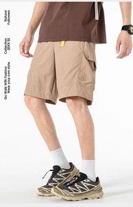 Detailed close-up of khaki cargo shorts showing side utility pocket and fabric texture